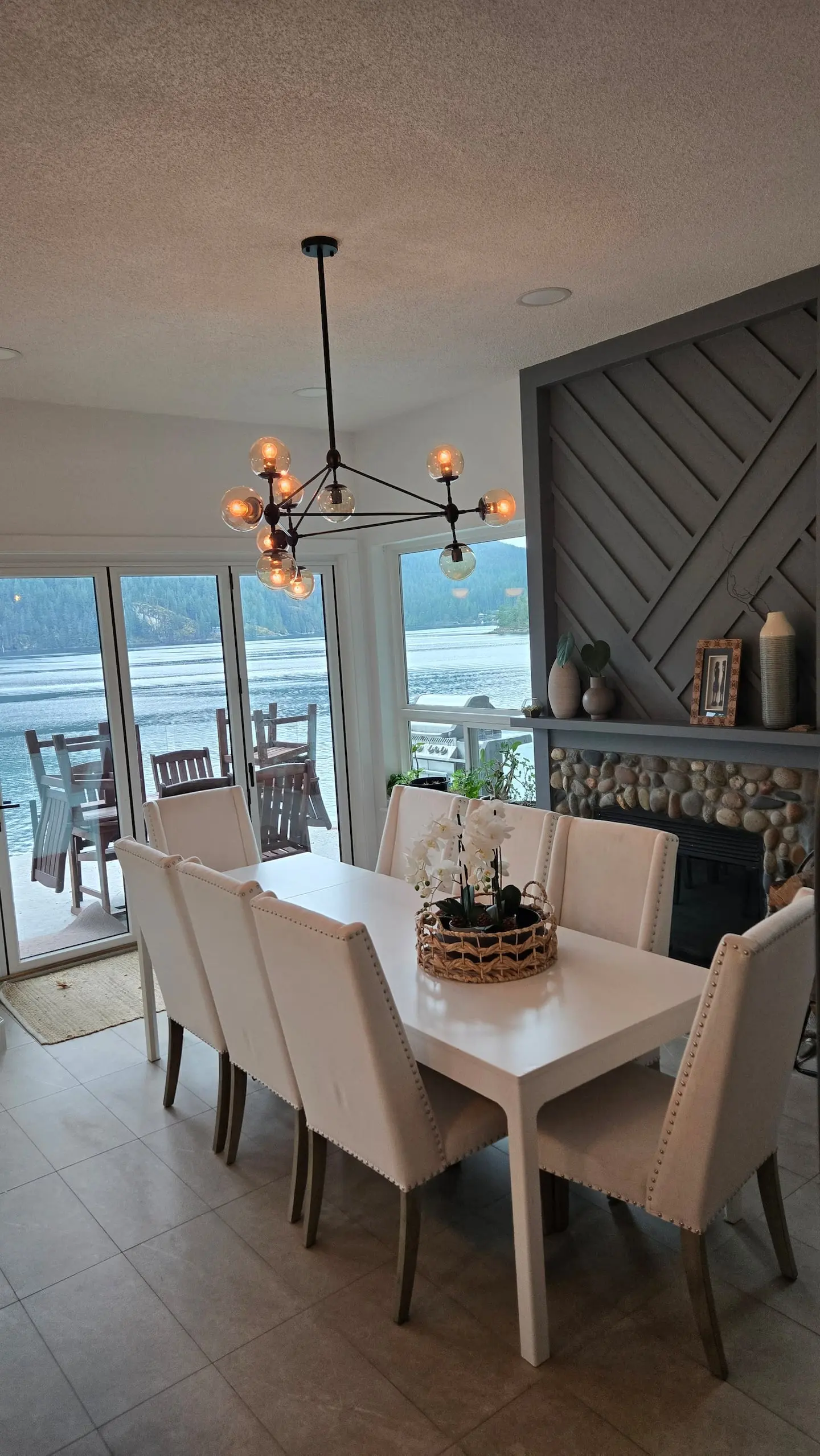 Dining table beside a fireplace with water views