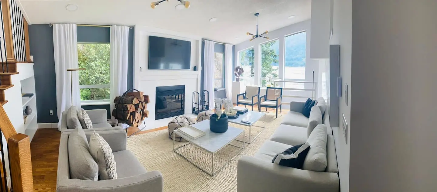 Living room with two sofas, fireplace and tall windows