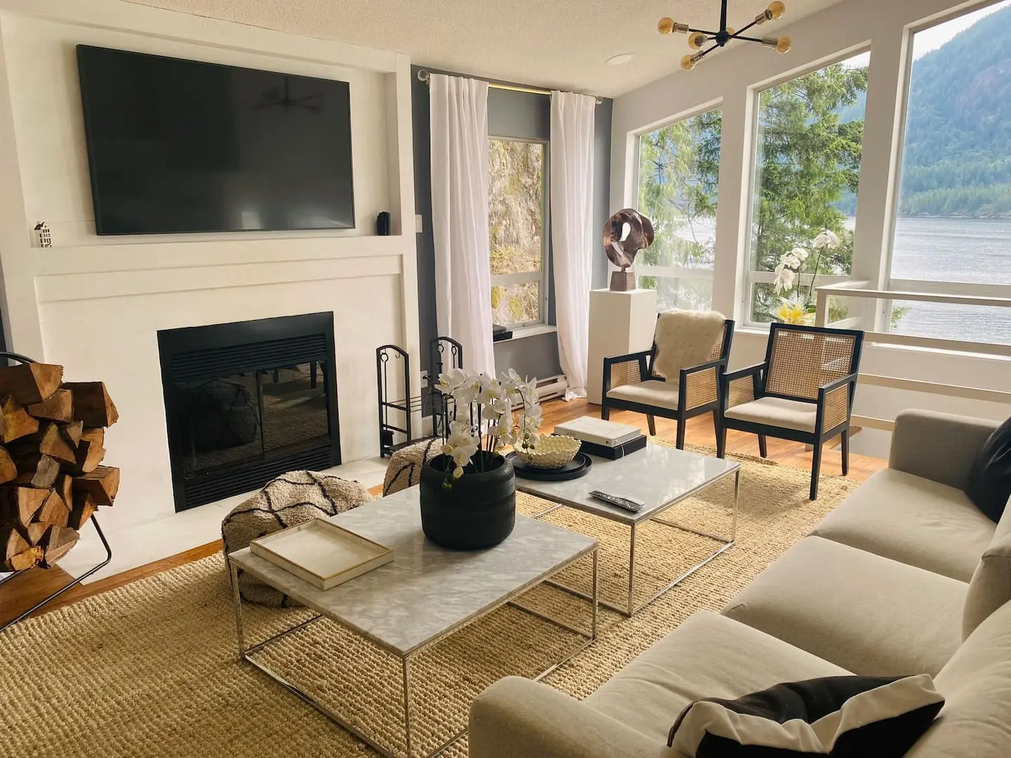 Living room with fireplace, TV and water view