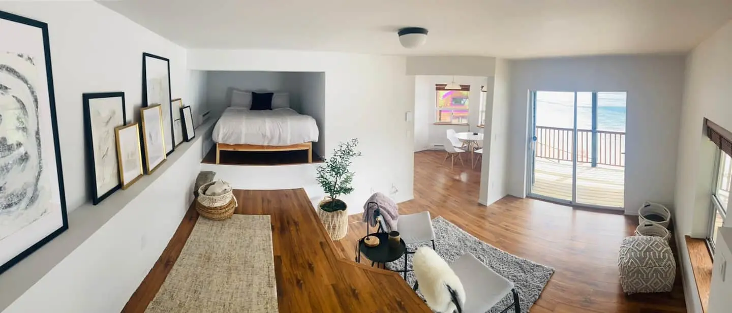 Bedroom 2: long room with bed in an alcove and a door to the deck