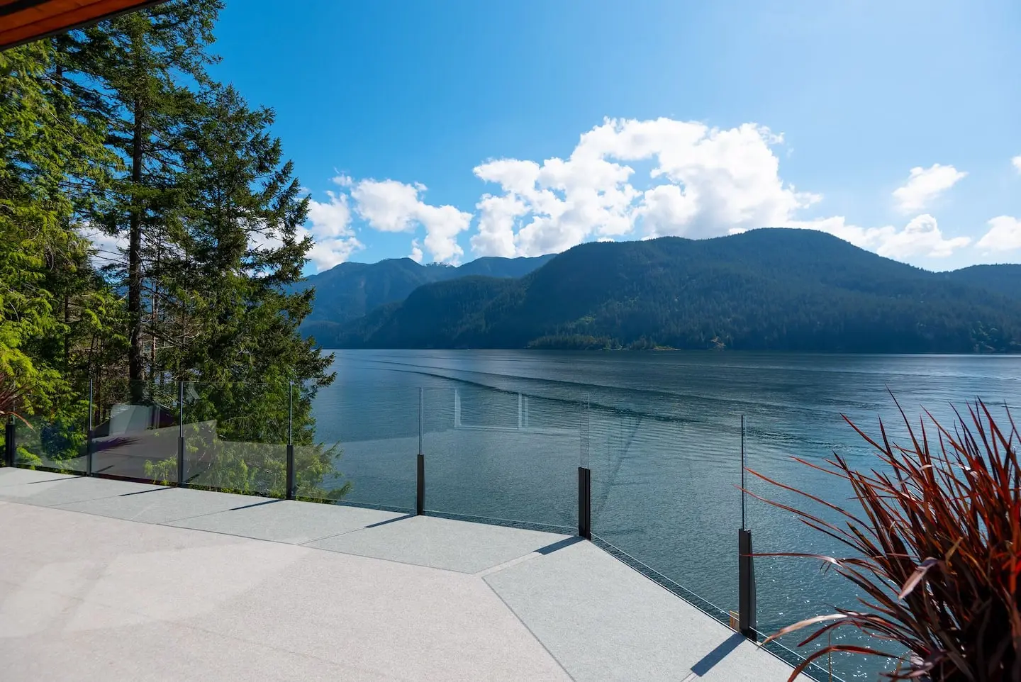 Glass-railed deck with mountain and water views