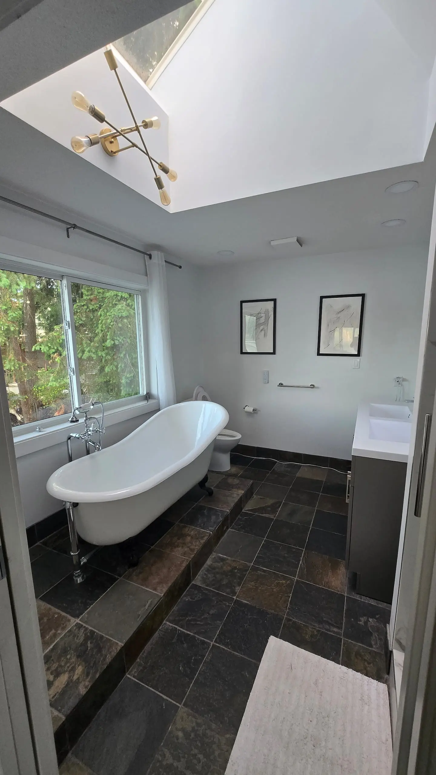 Bathroom with clawfoot tub under a skylight